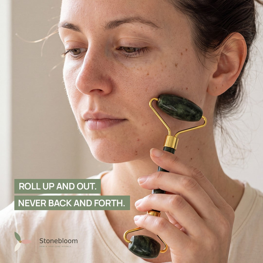 Woman using the jade facial roller on her cheek, rolling upward and outward toward the ear